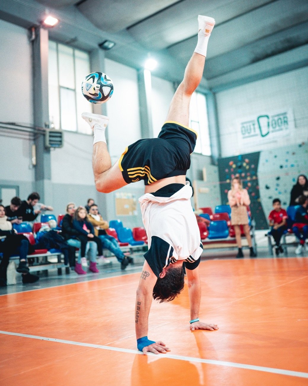 Verticale con il pallone in equilibrio durante uno show in palazzetto